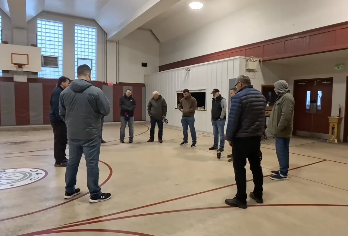 Pastors and leaders praying together in the former school gym in Minersville